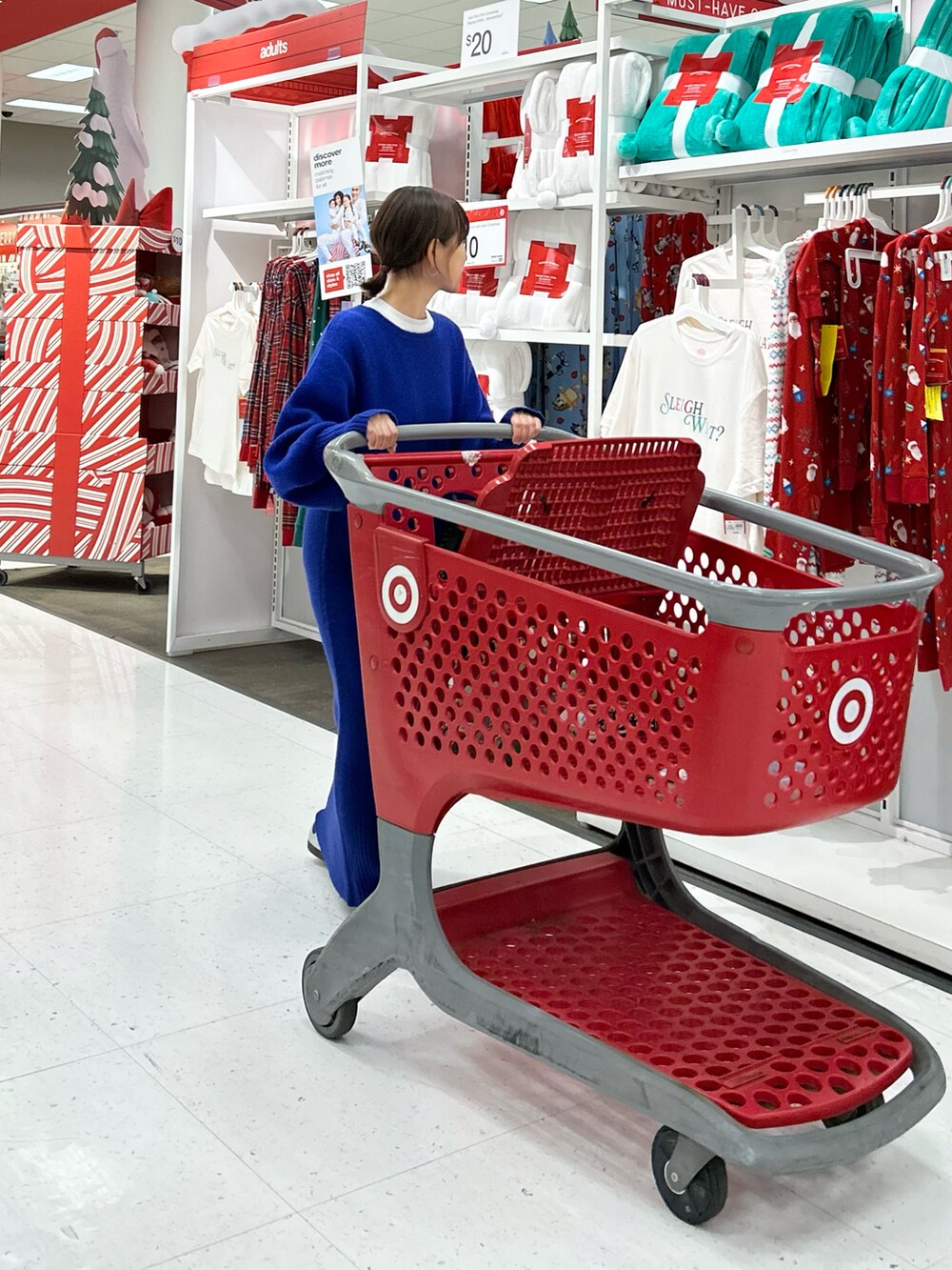 ブルー系のワンピース、ブラック系のトートバッグ、シルバー系のスニーカーを着用したレディースの冬コーディネートの4枚目の写真