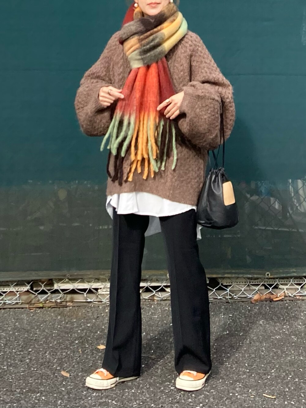 ブラウン系のニット/セーター、ホワイト系のシャツ/ブラウス、ブラック系のその他パンツを着用したレディースの冬コーディネートの2枚目の写真