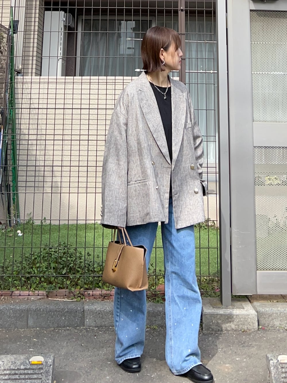 ブラック系のシャツ/ブラウス、ベージュ系のテーラードジャケット、ブラウン系のハンドバッグを着用したレディースの冬コーディネートの3枚目の写真