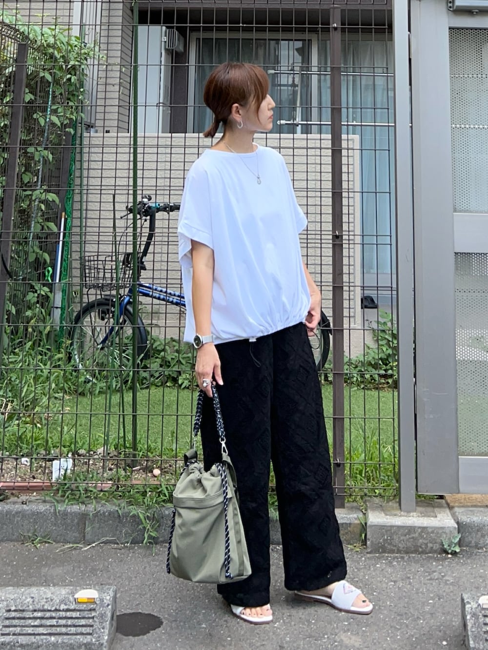 ブラック系のその他パンツ、ホワイト系のサンダル、ホワイト系のTシャツ/カットソーを着用したレディースの夏コーディネートの2枚目の写真