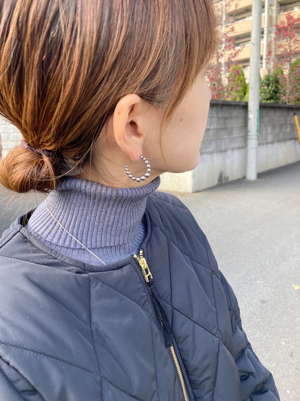 ブラック系のその他アウター、グレー系のニット/セーター、ホワイト系のスカートを着用したレディースの秋コーディネートの5枚目の写真