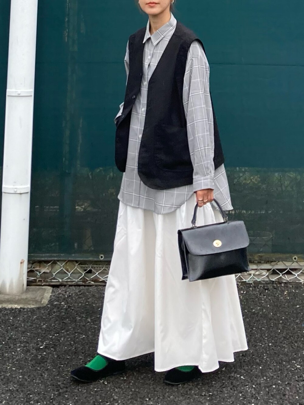 ブラック系のベスト、ホワイト系のスカート、ブラウン系のシャツ/ブラウスを着用したレディースの夏コーディネートの4枚目の写真