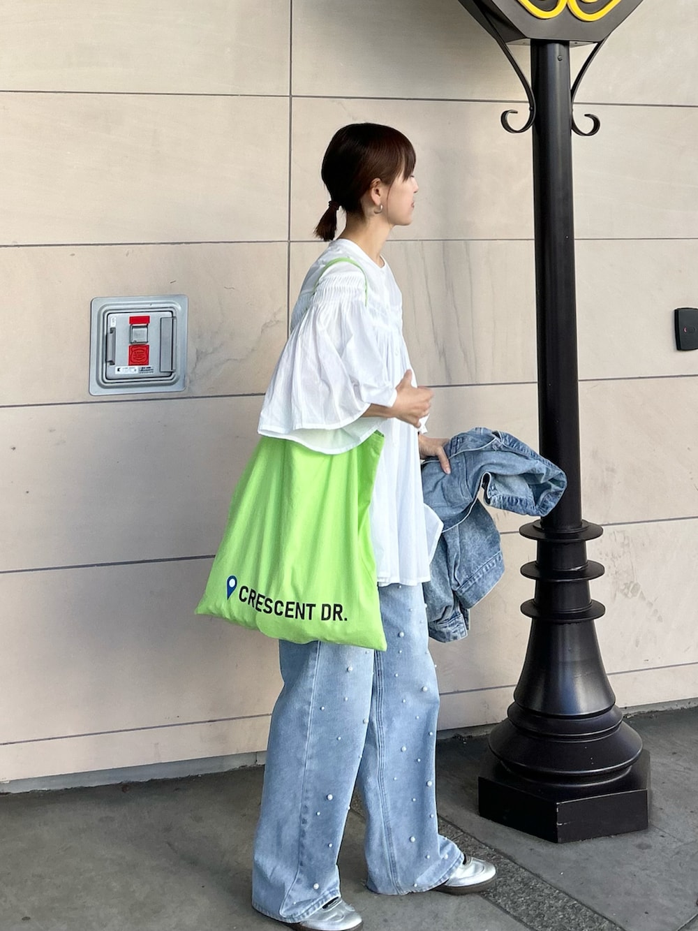 ホワイト系のシャツ/ブラウス、グリーン系のトートバッグ、シルバー系のスニーカーを着用したレディースの春コーディネートの5枚目の写真