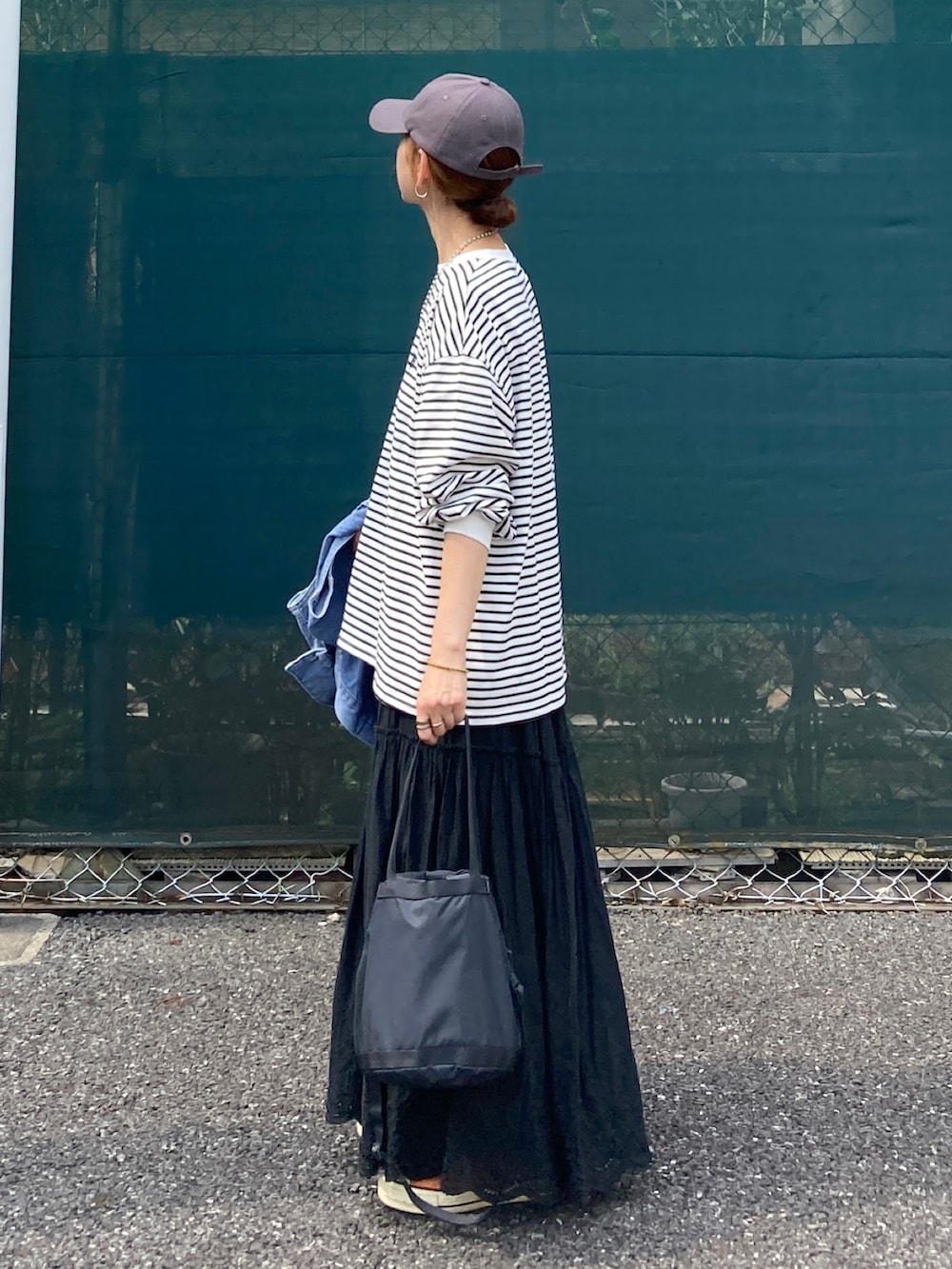 ホワイト系のTシャツ/カットソー、ブラック系のスカート、ブラック系のバッグを着用したレディースの夏コーディネートの2枚目の写真