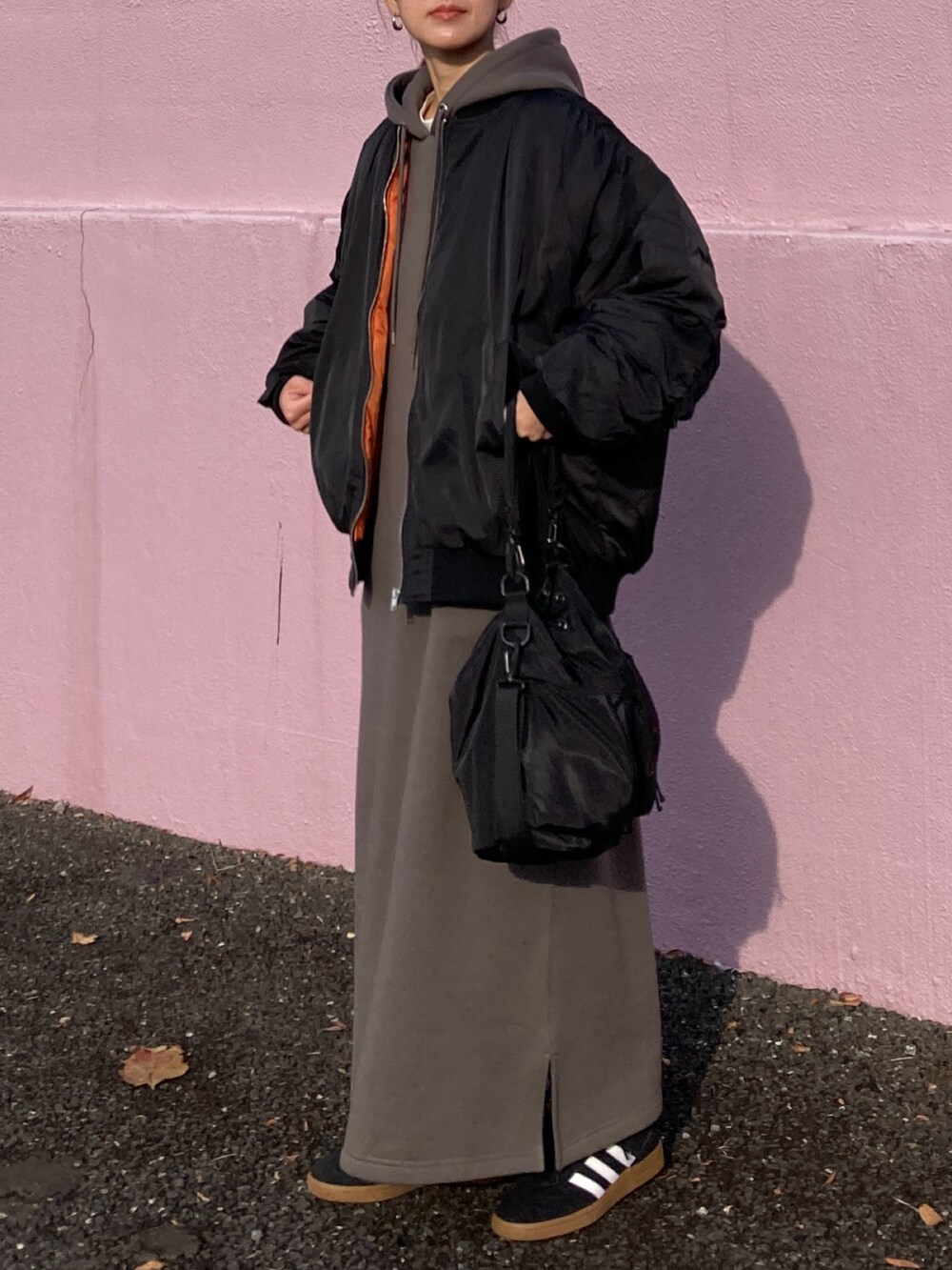 ブラック系のブルゾン、グレー系のワンピース、ブラック系のショルダーバッグを着用したレディースの冬コーディネートの2枚目の写真