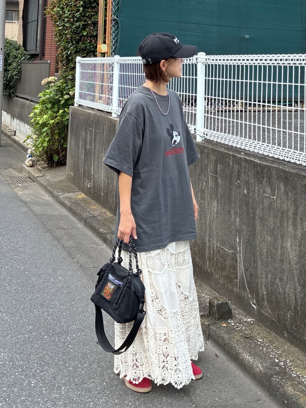 グレー系のTシャツ/カットソー、ホワイト系のスカート、ブラック系のトートバッグを着用したレディースの夏コーディネートの4枚目の写真
