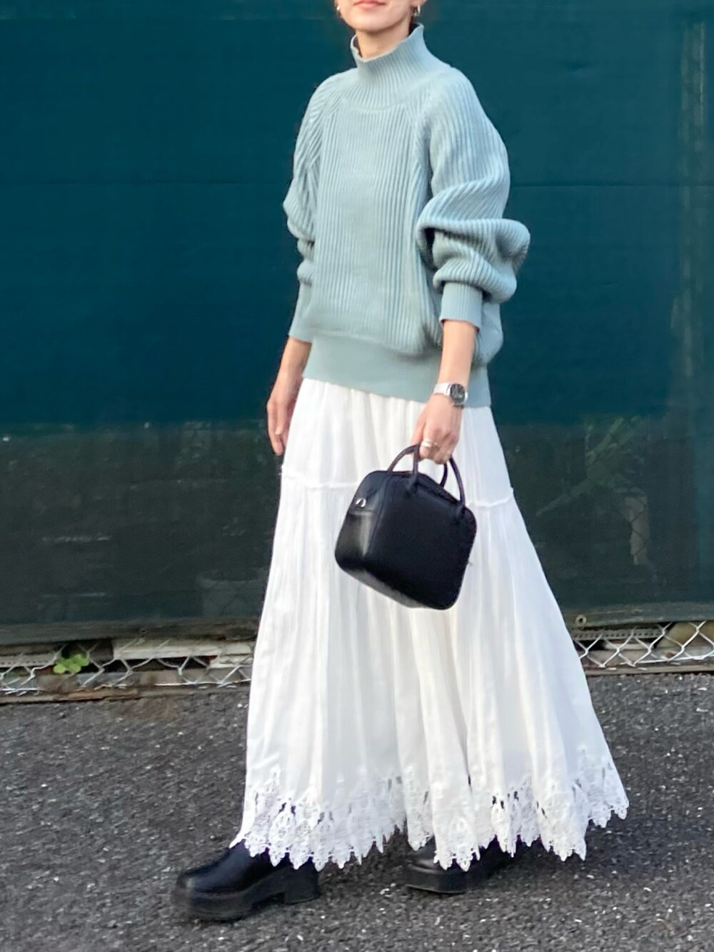 ブルー系のニット/セーター、ブラック系のボストンバッグを着用したレディースの秋コーディネートの3枚目の写真