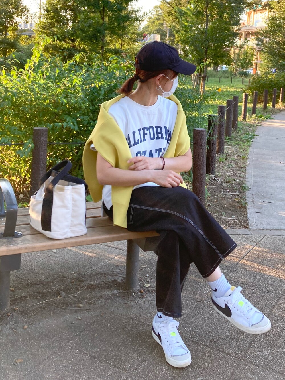 ホワイト系のTシャツ/カットソー、イエロー系のカーディガン/ボレロ、ブラック系のデニムパンツを着用したレディースの秋コーディネートの3枚目の写真