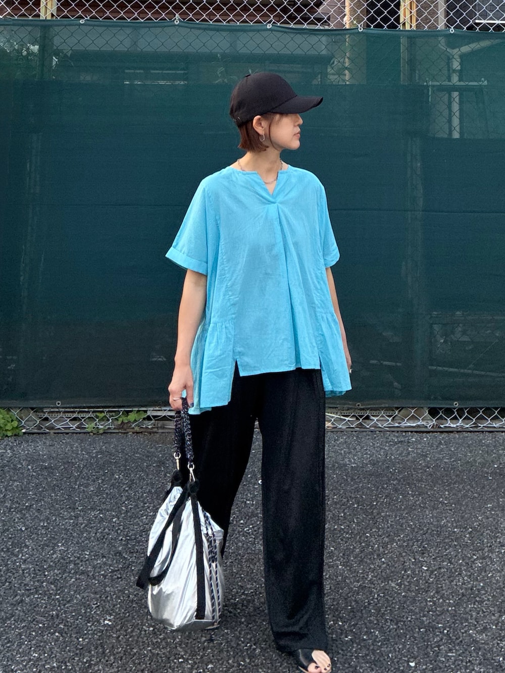 ブルー系のシャツ/ブラウス、ブラック系のスラックス、シルバー系のショルダーバッグを着用したレディースの夏コーディネートの4枚目の写真