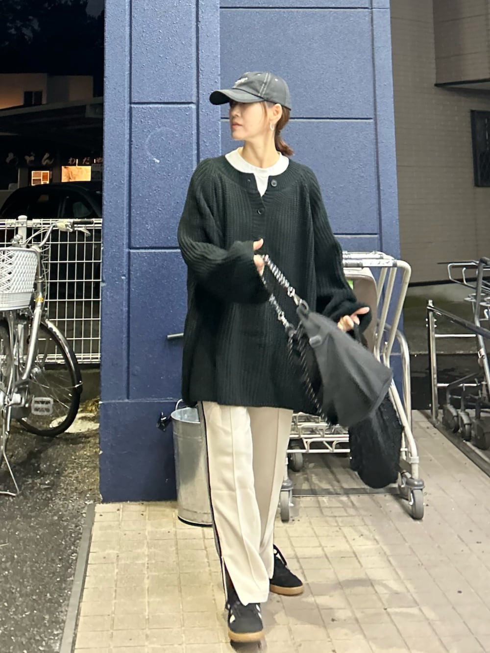 ブラック系のニット/セーター、ベージュ系のスウェットパンツ、ブラック系のトートバッグを着用したレディースの秋コーディネートの3枚目の写真