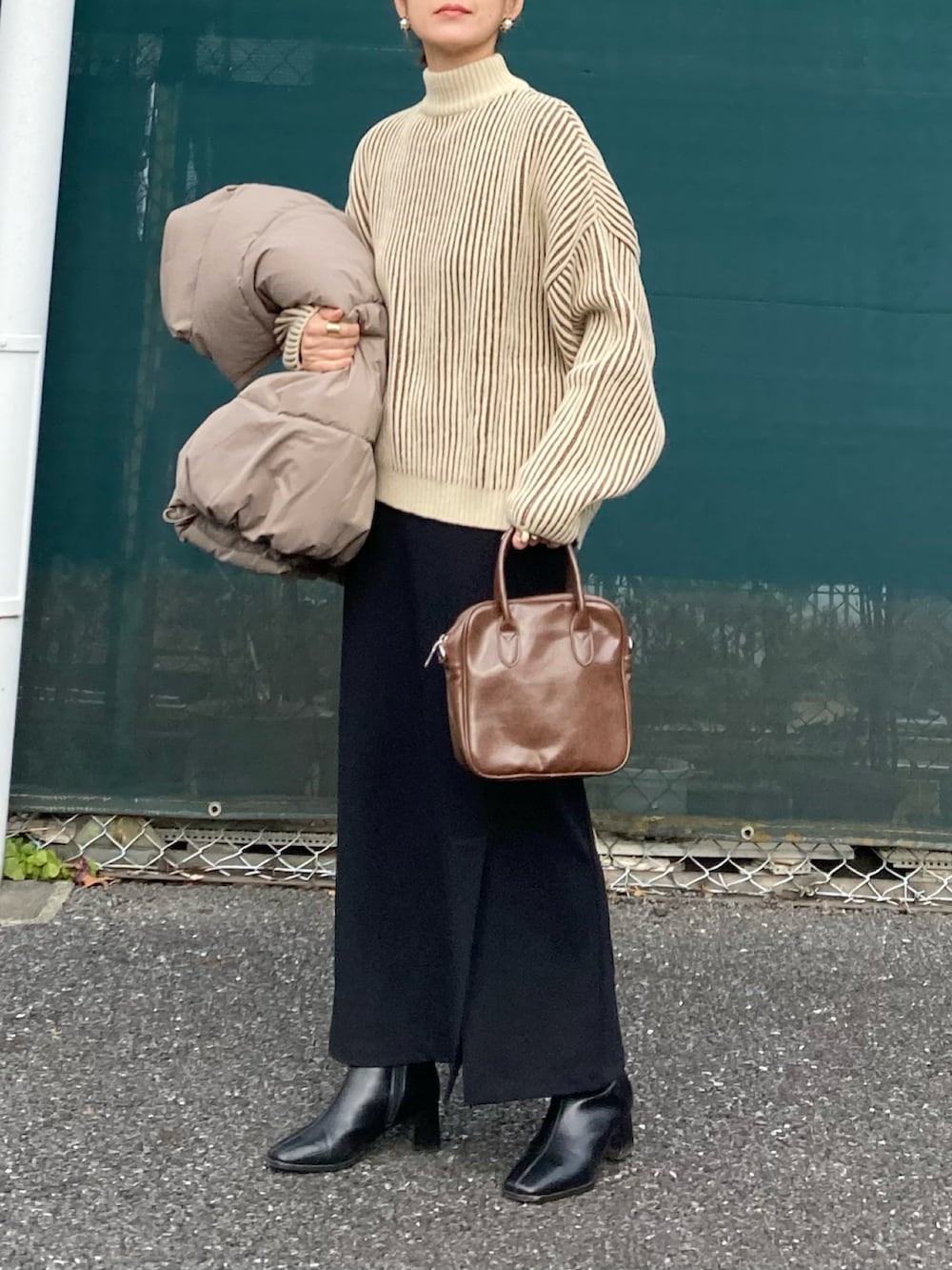 ブラウン系のニット/セーター、ベージュ系のダウンベスト、ブラウン系のショルダーバッグを着用したレディースの冬コーディネートの4枚目の写真