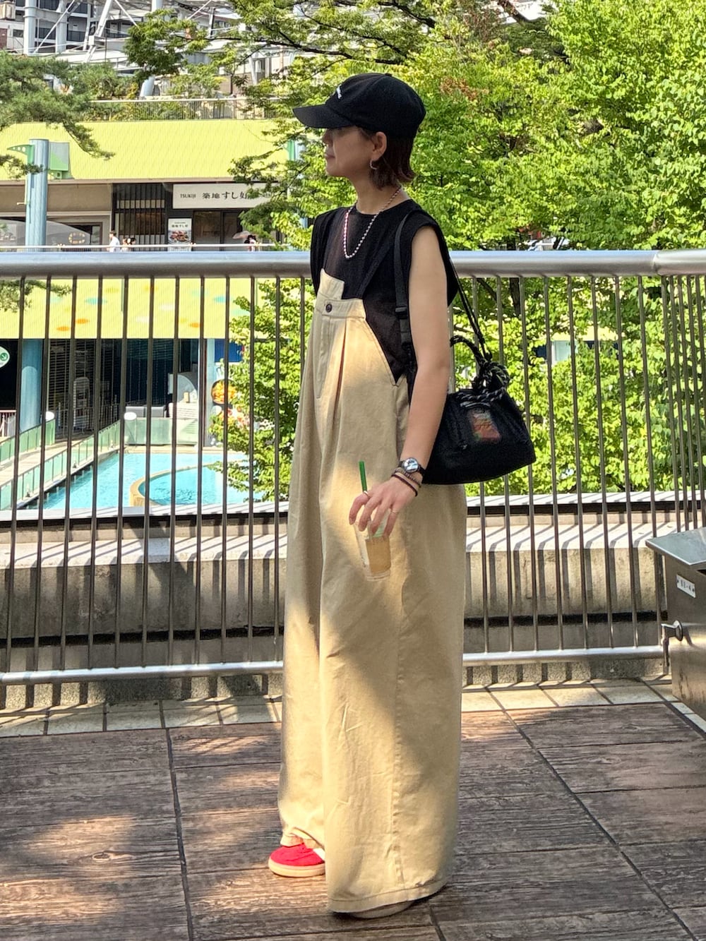 ブラック系のTシャツ/カットソー、ベージュ系のサロペット/オーバーオール、ブラック系のトートバッグを着用したレディースの夏コーディネートの3枚目の写真