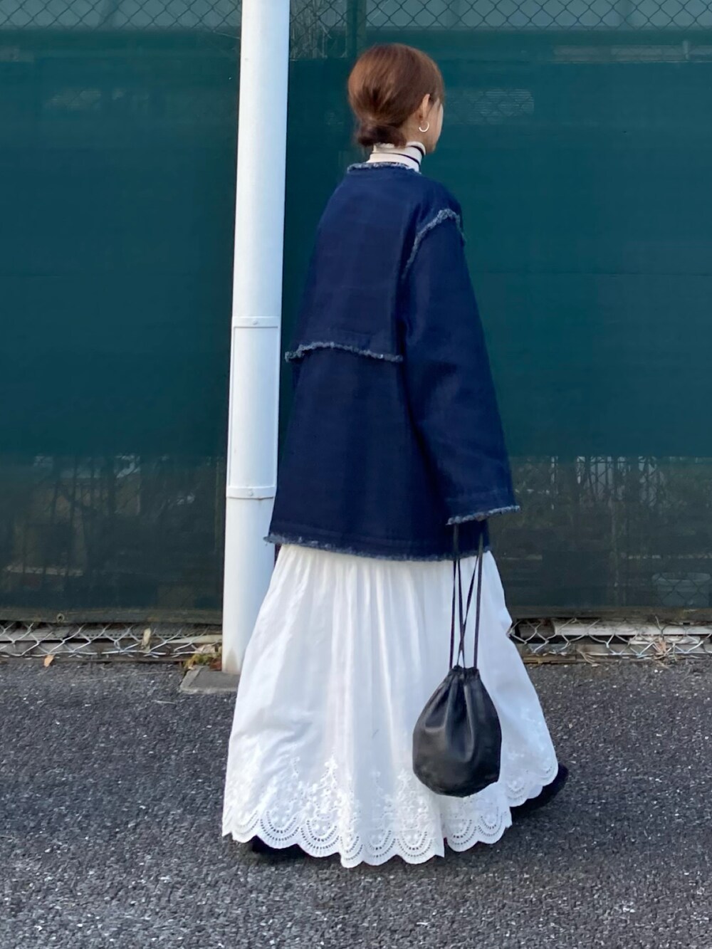 ブルー系のデニムジャケット、ホワイト系のスカート、ホワイト系のニット/セーターを着用したレディースの冬コーディネートの5枚目の写真