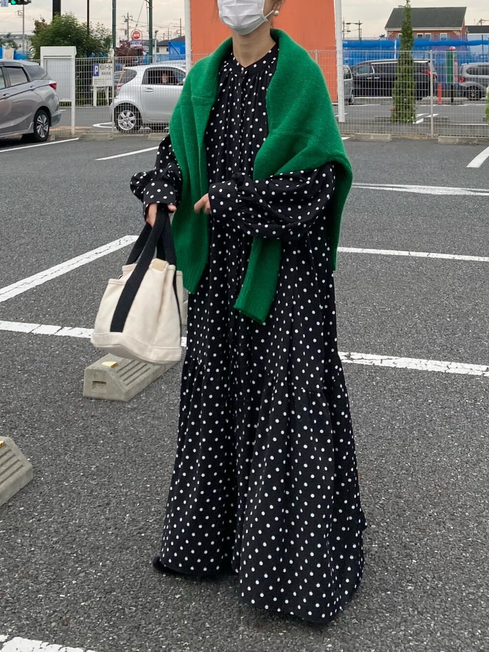 ブラック系のシャツワンピース、グリーン系のニット/セーター、ホワイト系のトートバッグを着用したレディースの秋コーディネートの4枚目の写真