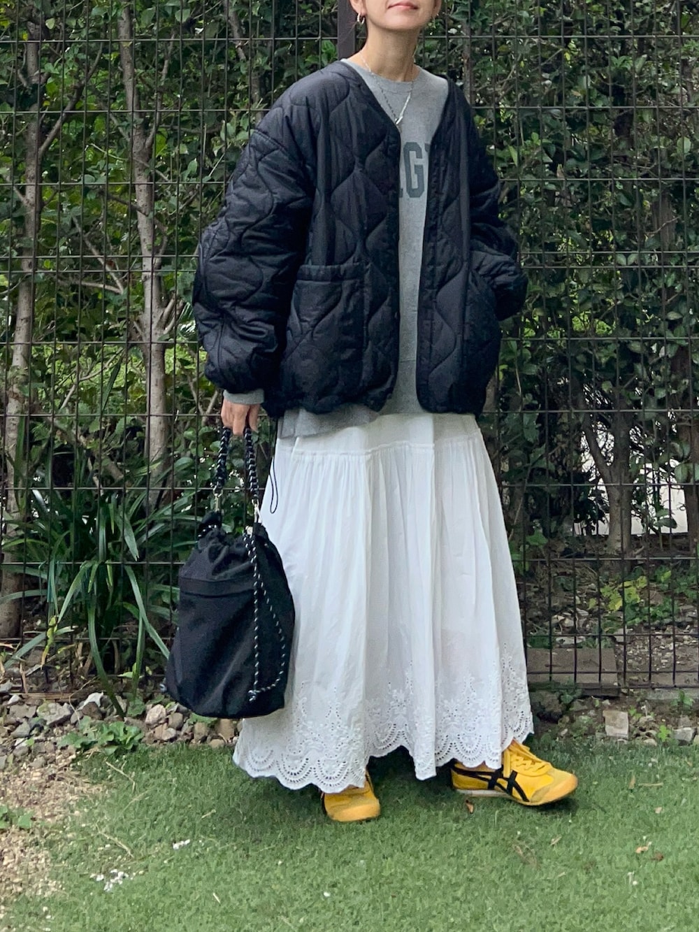 ブラック系のノーカラージャケット、ブラック系のトートバッグ、グレー系のスウェットを着用したレディースの秋コーディネートの2枚目の写真