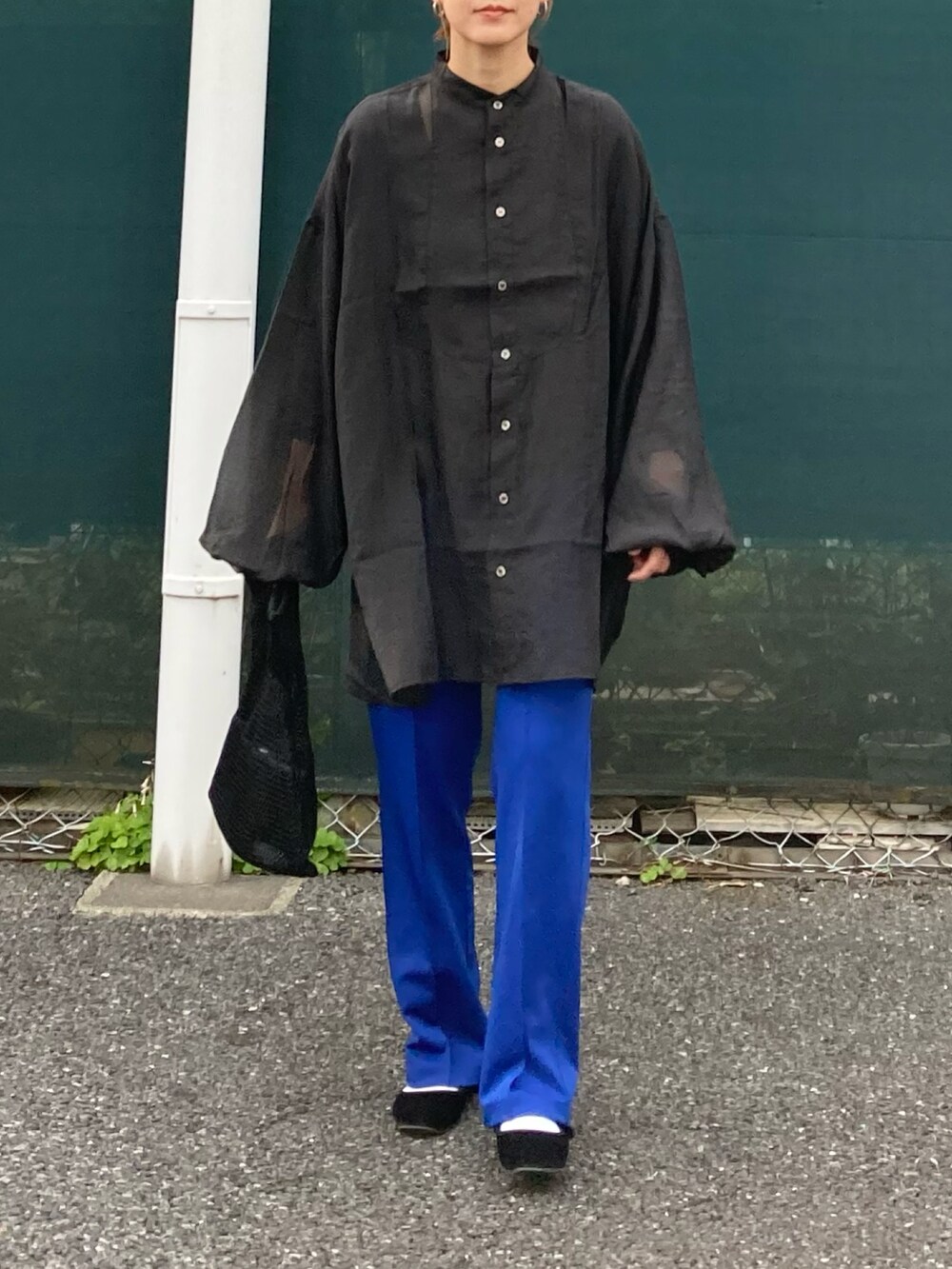 ブラック系のシャツ/ブラウス、ブラック系のショルダーバッグ、ブルー系のその他パンツを着用したレディースの春コーディネートの2枚目の写真