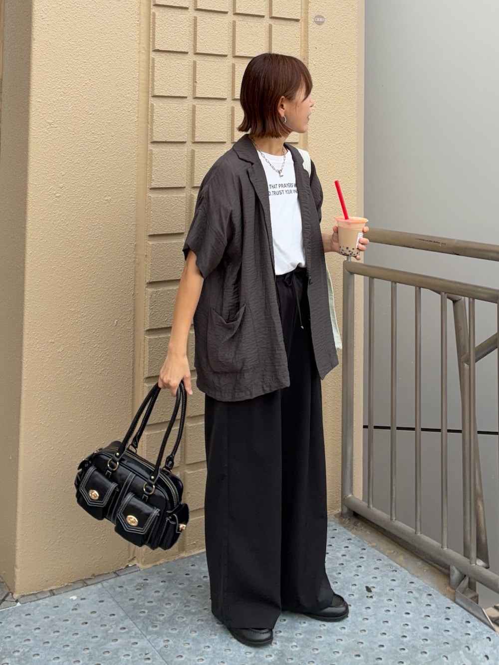 ホワイト系のTシャツ/カットソー、グレー系のテーラードジャケット、ブラック系のスラックスを着用したレディースの夏コーディネートの3枚目の写真