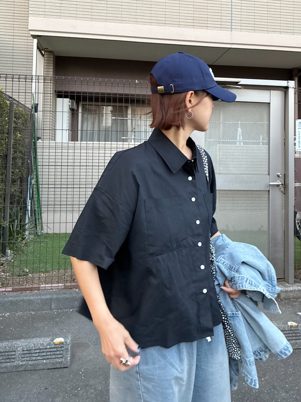 ブラック系のシャツ/ブラウス、ブルー系のデニムパンツ、ブルー系のキャップを着用したレディースの春コーディネートの4枚目の写真