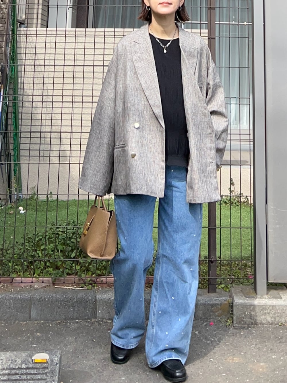 ブラック系のシャツ/ブラウス、ベージュ系のテーラードジャケット、ブラウン系のハンドバッグを着用したレディースの冬コーディネートの2枚目の写真