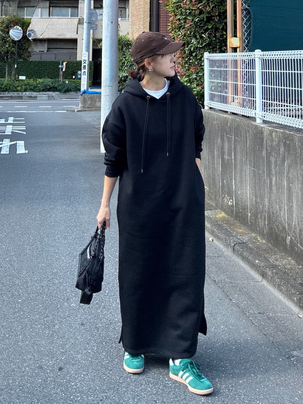 ブラック系のワンピース、ブラック系のトートバッグ、グリーン系のスニーカーを着用したレディースの夏コーディネートの2枚目の写真
