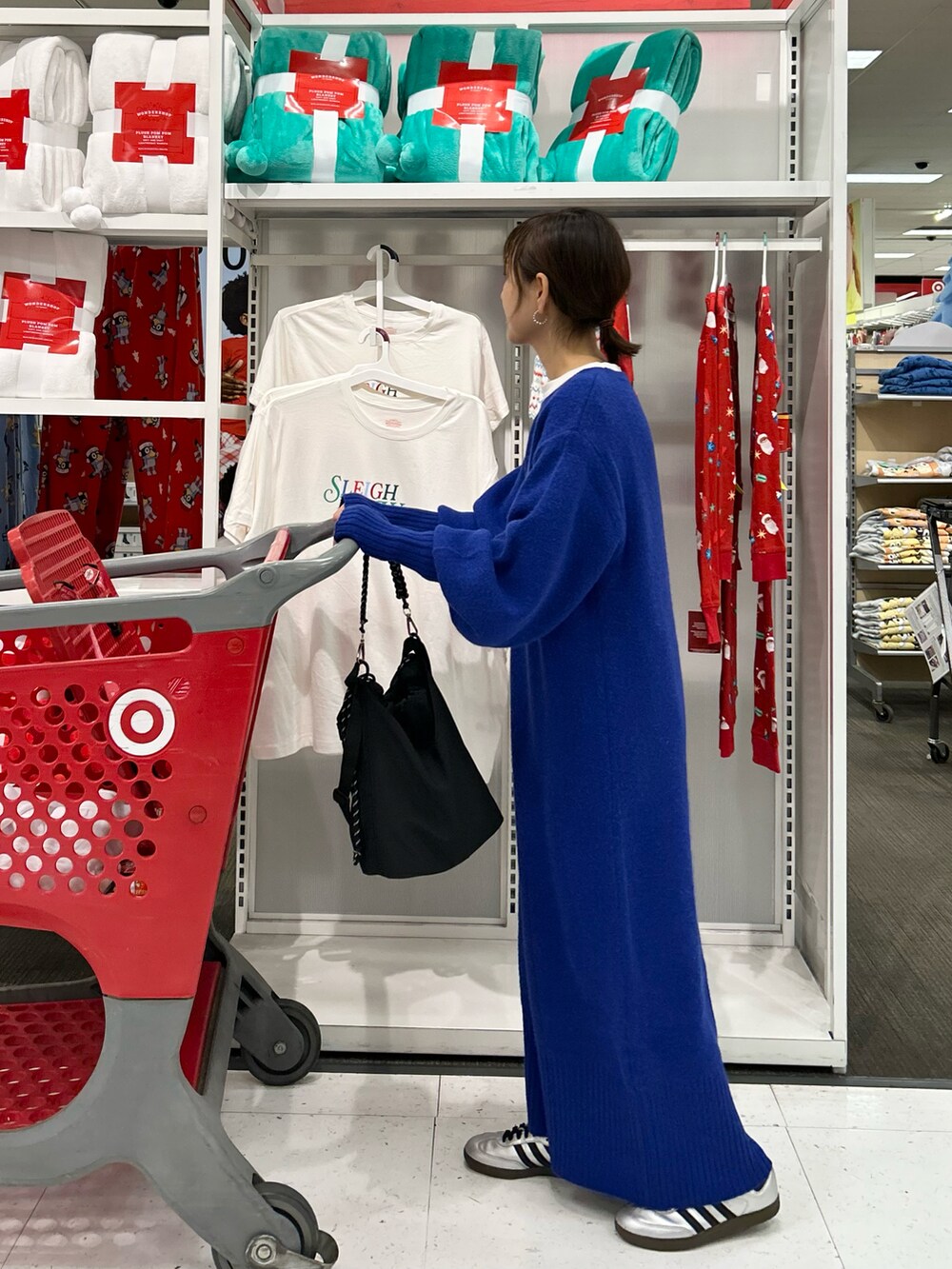 ブルー系のワンピース、ブラック系のトートバッグ、シルバー系のスニーカーを着用したレディースの冬コーディネートの3枚目の写真