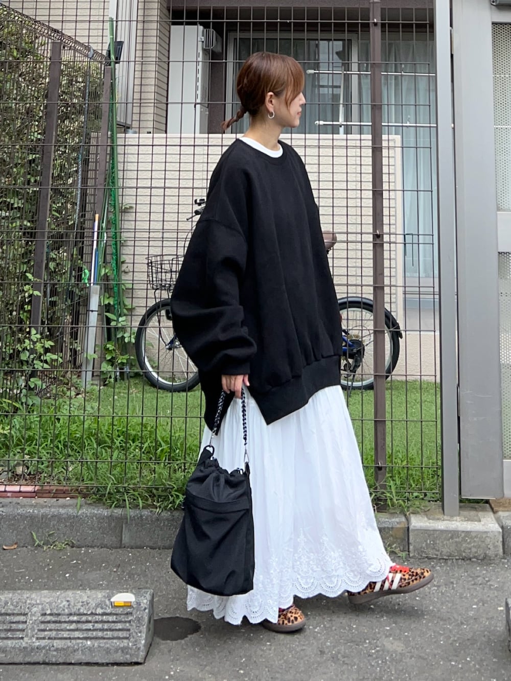 ブラック系のトートバッグ、ブラック系のスウェット、ホワイト系のスカートを着用したレディースの秋コーディネートの2枚目の写真