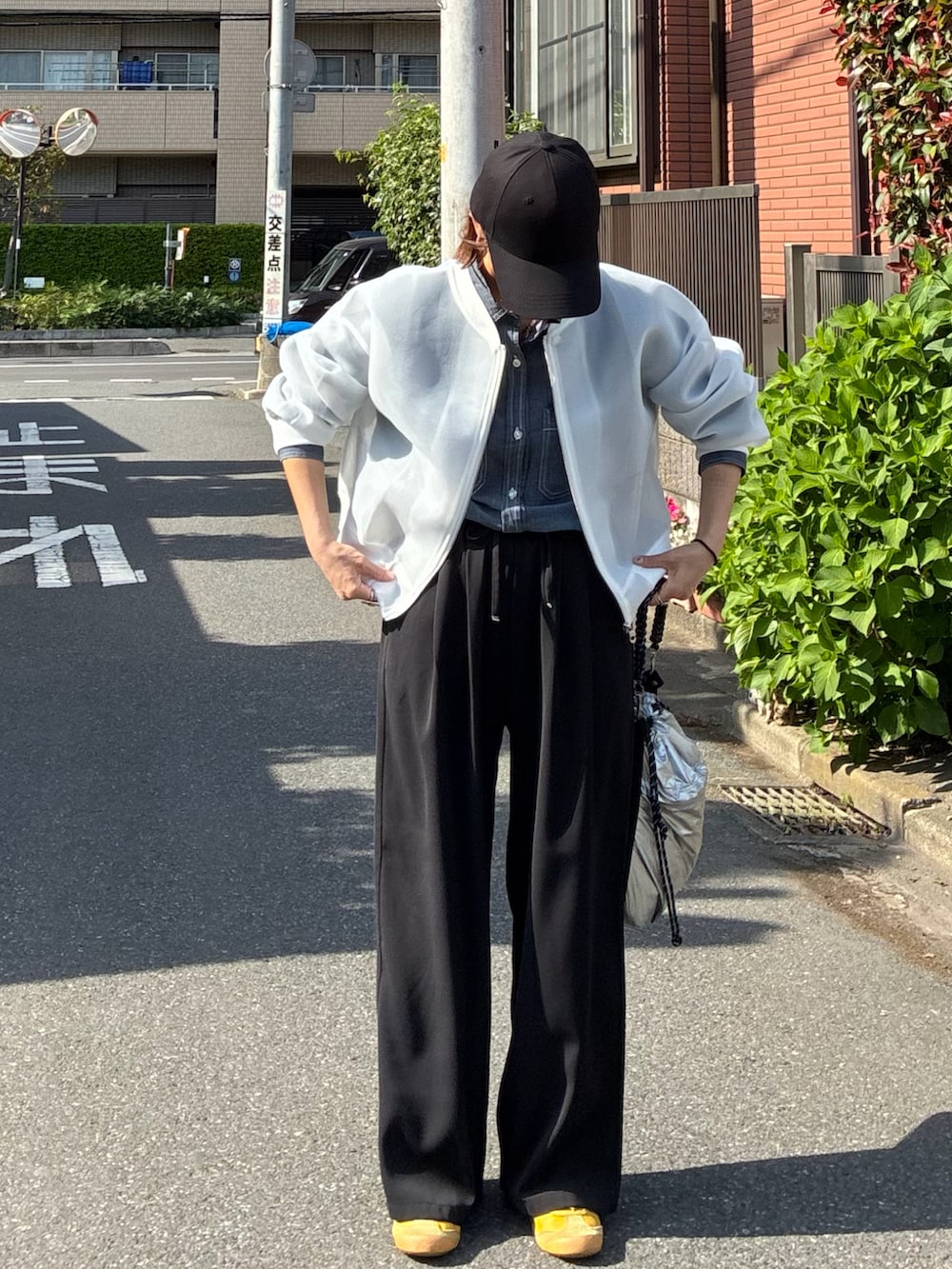 ブルー系のシャツ/ブラウス、ホワイト系のブルゾン、ブラック系のスラックスを着用したレディースの春コーディネートの3枚目の写真