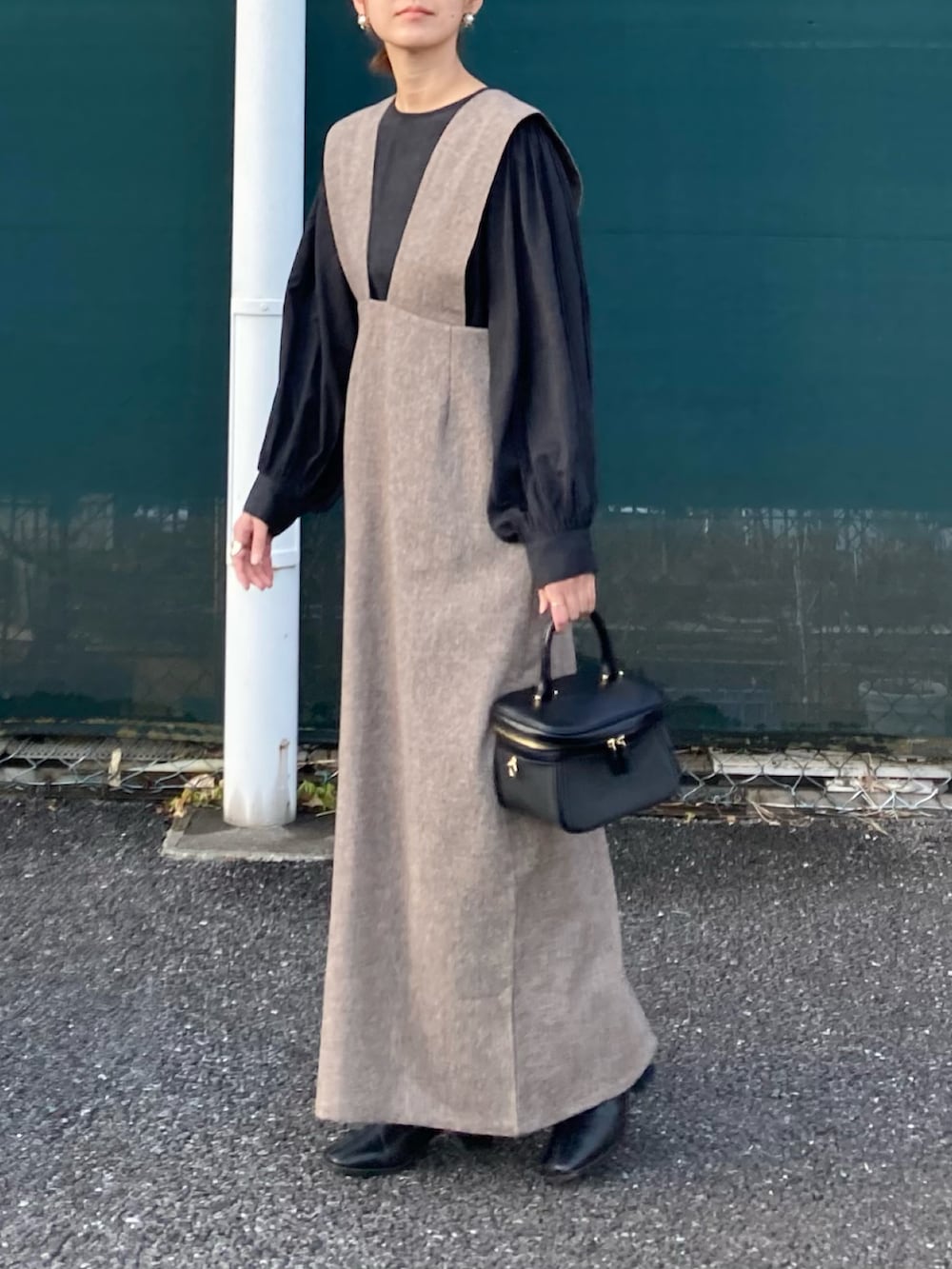 ブラック系のシャツ/ブラウス、ブラウン系のジャンパースカートを着用したレディースの冬コーディネートの3枚目の写真