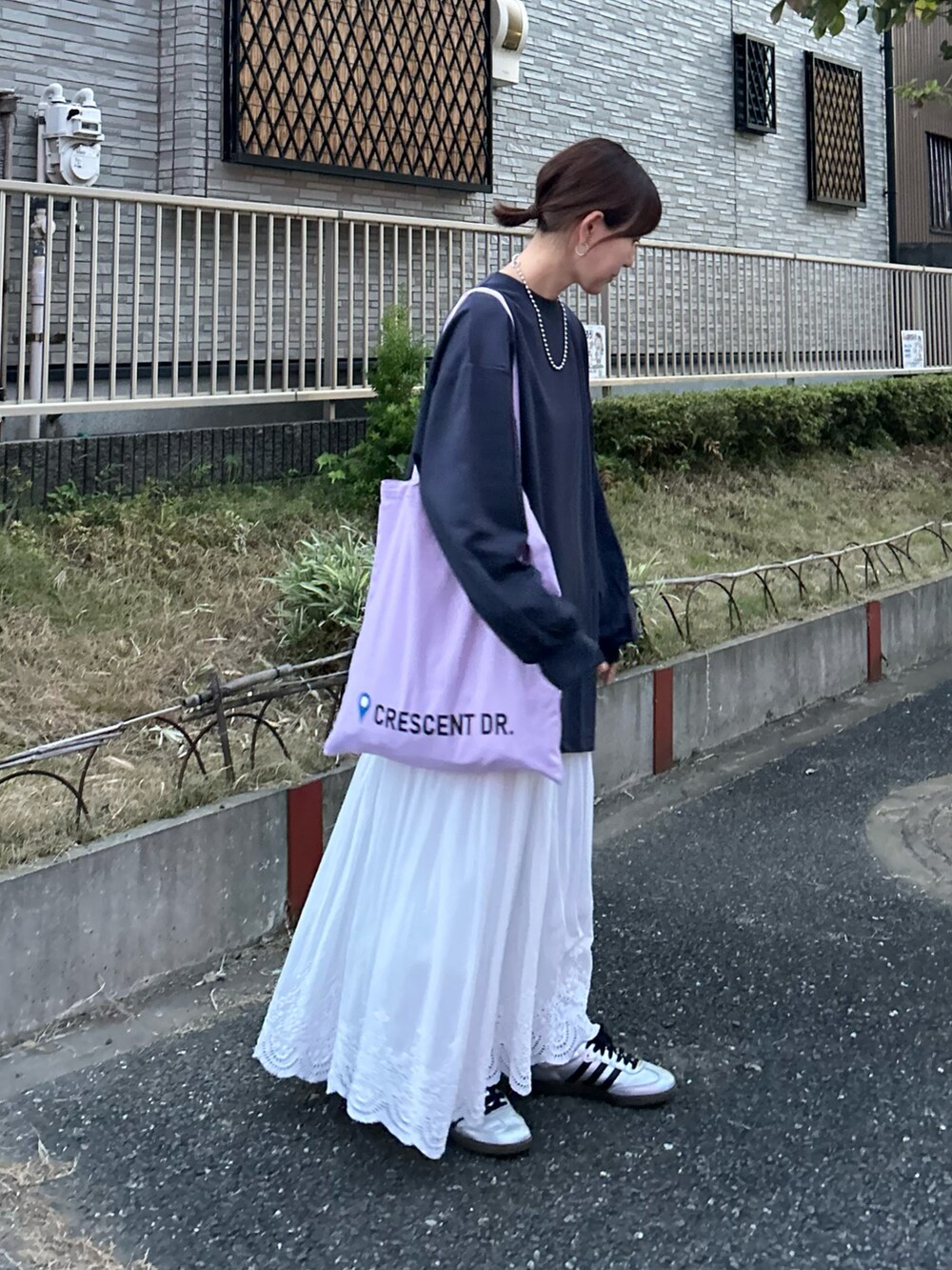 ブルー系のTシャツ/カットソー、ホワイト系のスカート、パープル系のトートバッグを着用したレディースの秋コーディネートの2枚目の写真