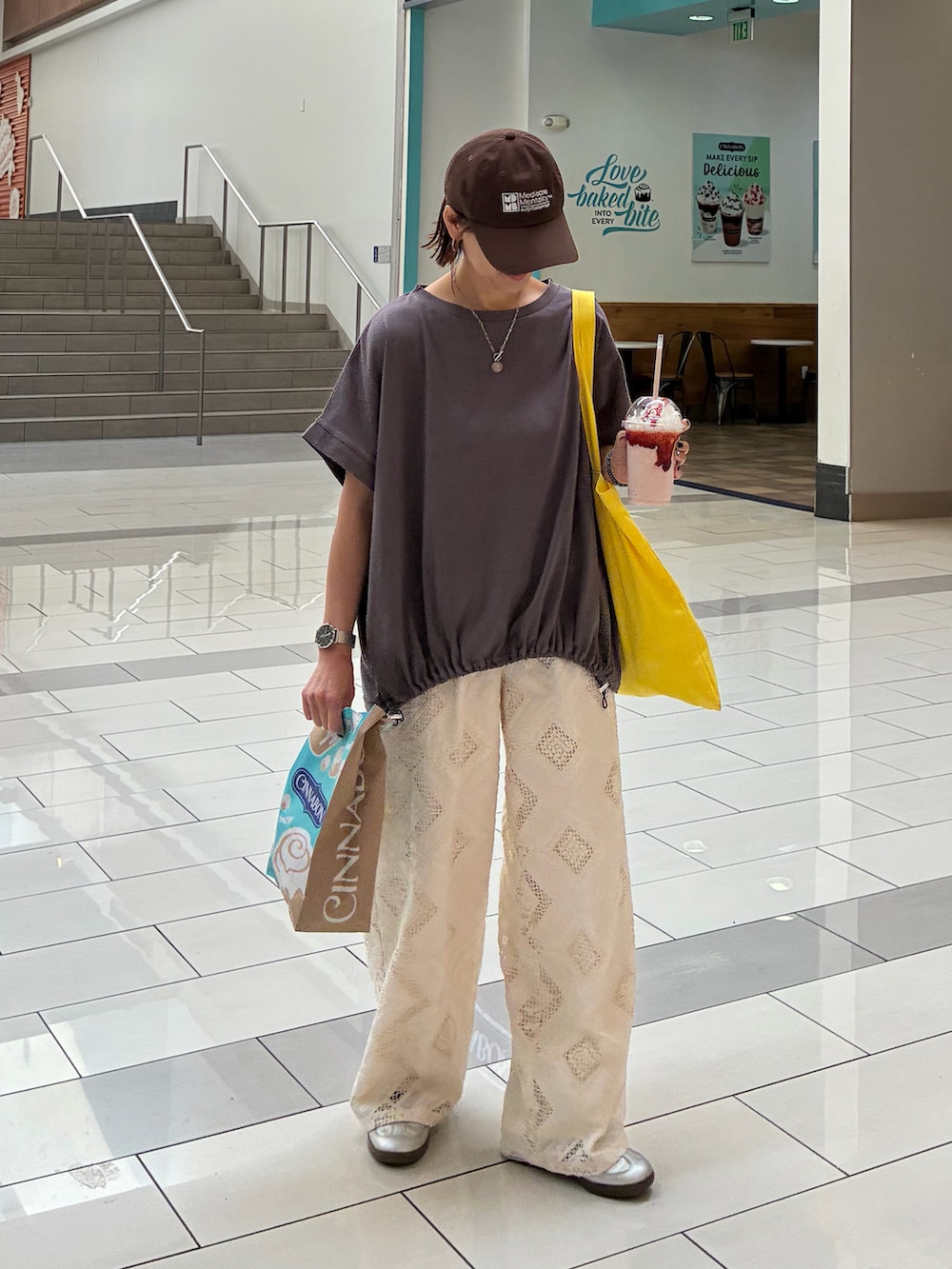 グレー系のTシャツ/カットソー、ホワイト系のスラックス、シルバー系のスニーカーを着用したレディースの春コーディネートの5枚目の写真