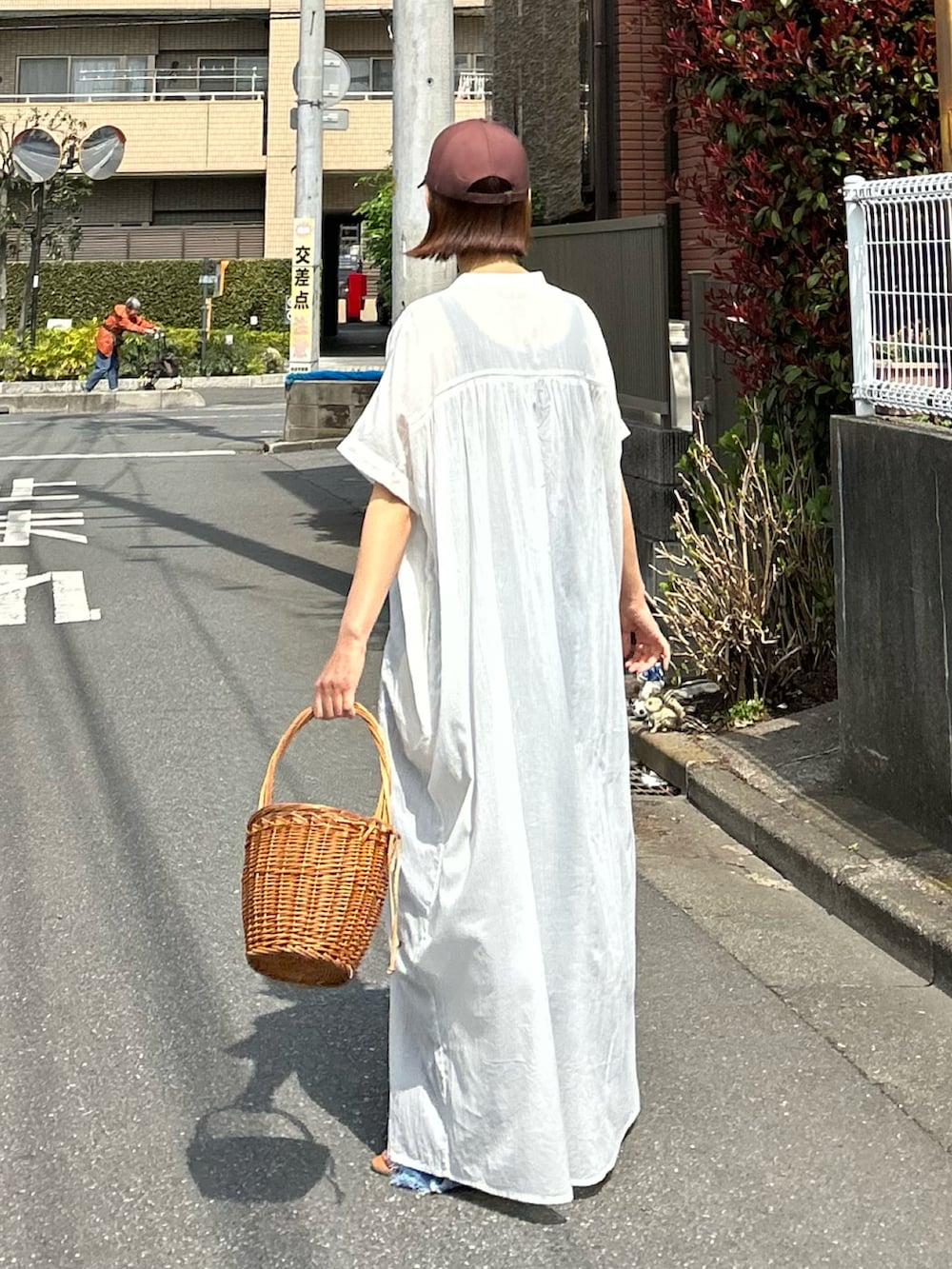 ホワイト系のワンピース、ブルー系のデニムパンツ、ブラウン系のキャップを着用したレディースの夏コーディネートの5枚目の写真