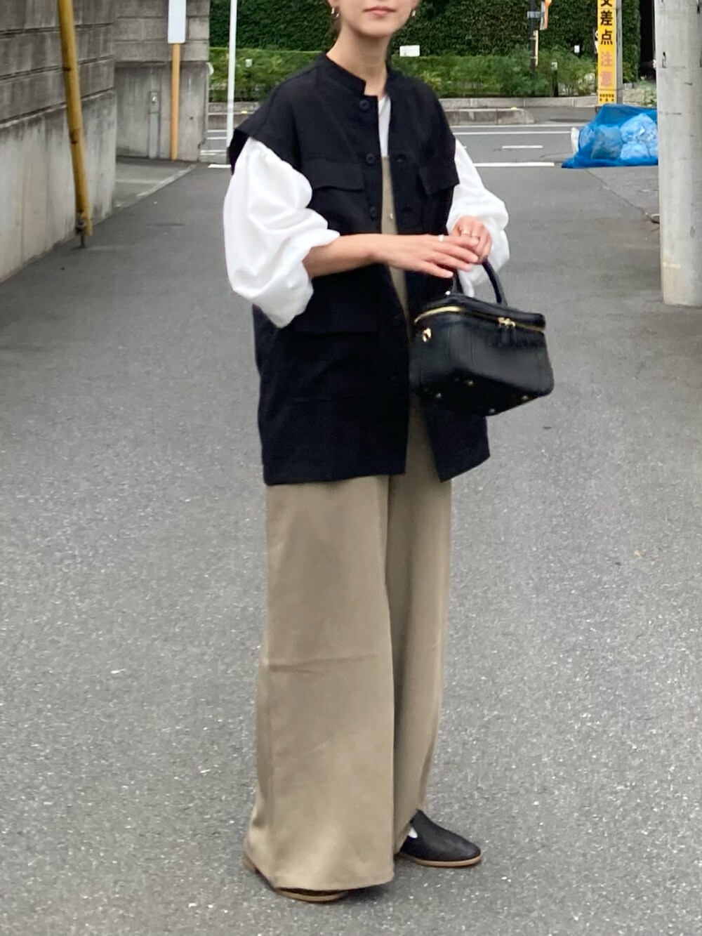 ブラック系のシャツ/ブラウス、ベージュ系のサロペット/オーバーオール、ホワイト系のシャツ/ブラウスを着用したレディースの夏コーディネートの4枚目の写真