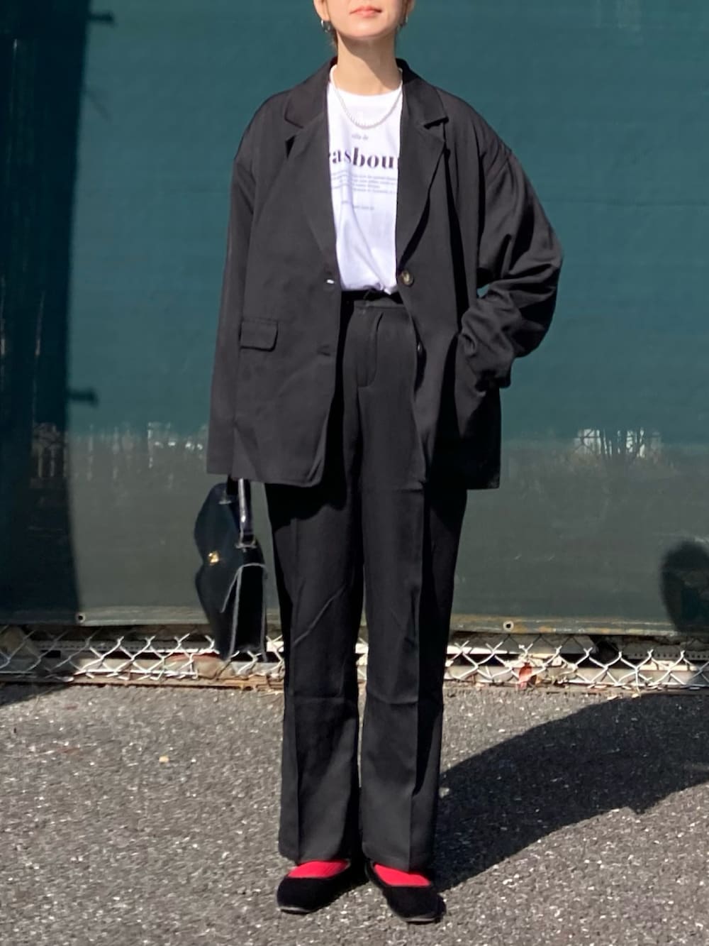 ブラック系のセットアップ、ホワイト系のTシャツ/カットソー、ブラック系のショルダーバッグを着用したレディースの冬コーディネートの3枚目の写真