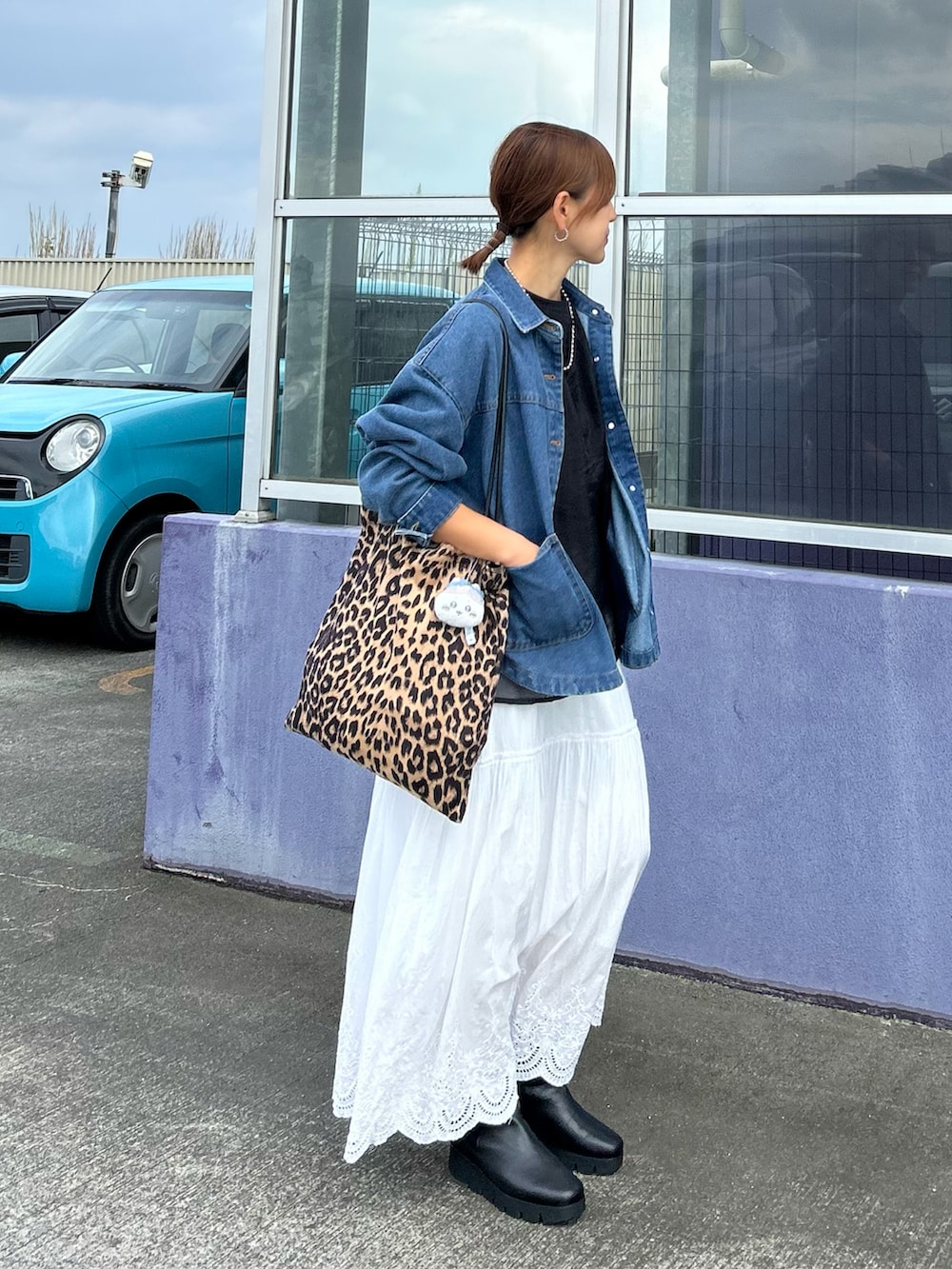 ホワイト系のスカート、ブルー系のデニムジャケット、ブラウン系のトートバッグを着用したレディースの秋コーディネートの5枚目の写真