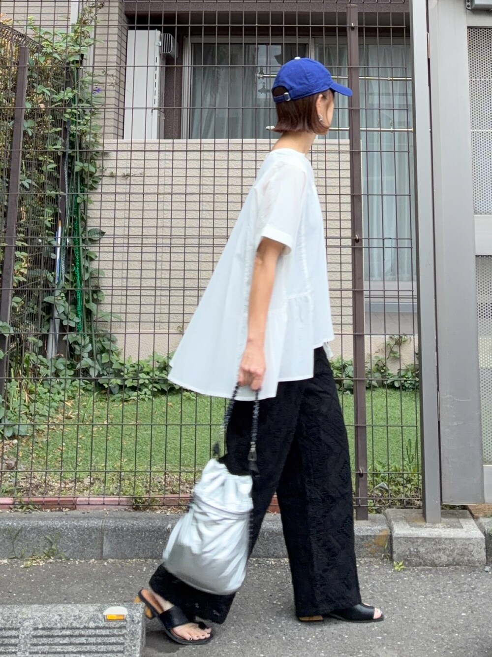 ホワイト系のシャツ/ブラウス、ブラック系のその他パンツ、シルバー系のショルダーバッグを着用したレディースの夏コーディネートの4枚目の写真