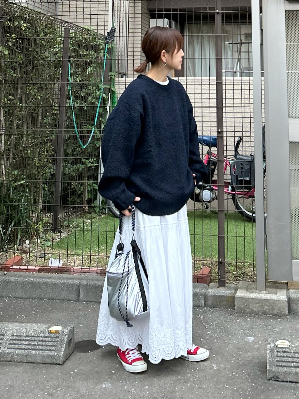 ブルー系のニット/セーター、シルバー系のトートバッグ、ホワイト系のスカートを着用したレディースの秋コーディネートの3枚目の写真