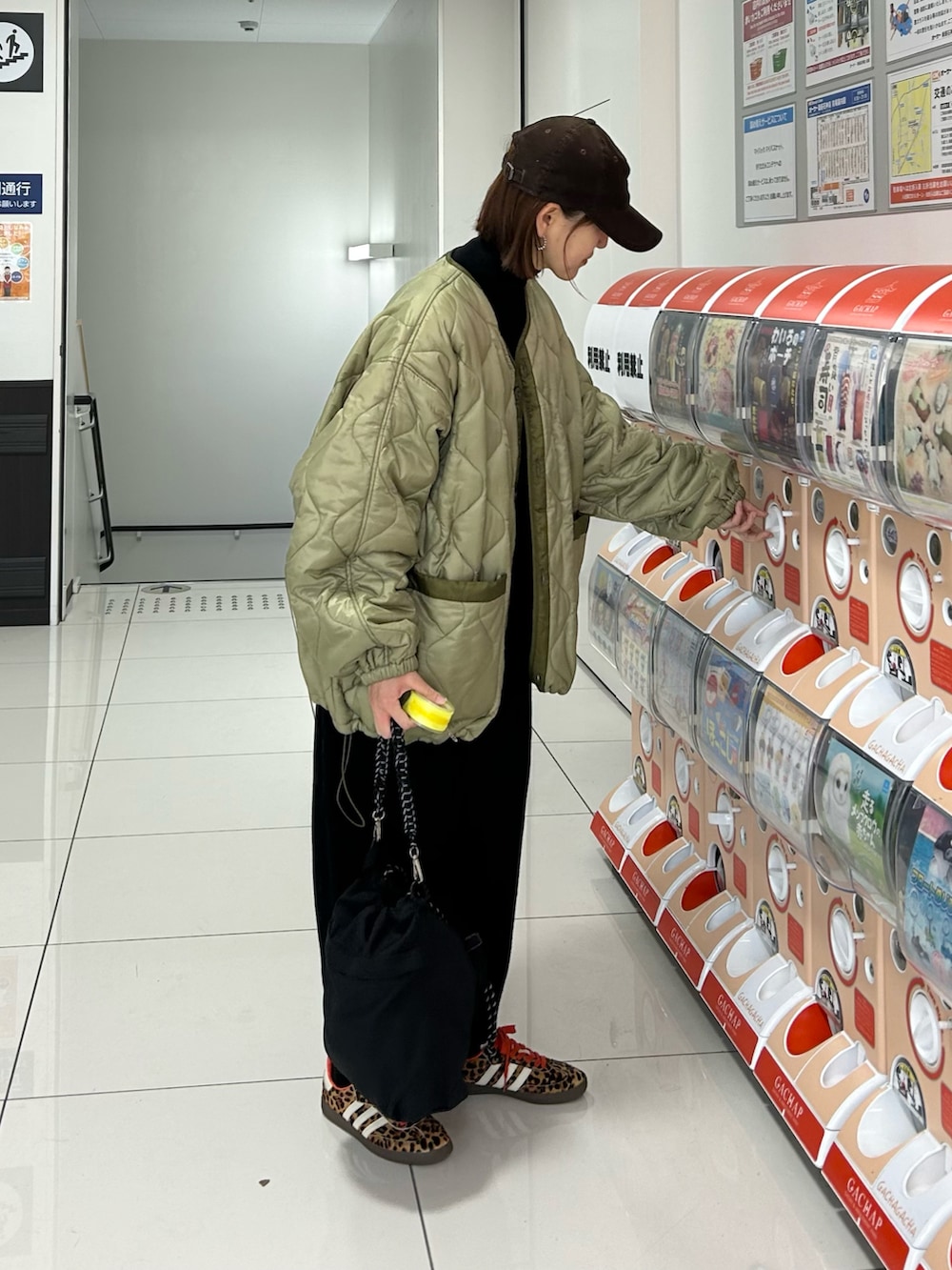 グリーン系のブルゾン、ブラック系のトートバッグ、ブラック系のスニーカーを着用したレディースの冬コーディネートの2枚目の写真