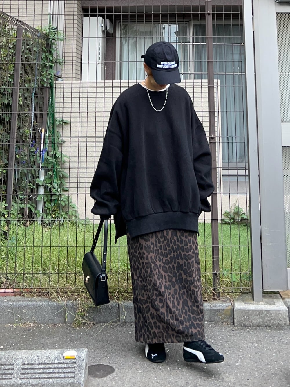 ブラック系のスウェット、ブラウン系のスカート、ブラック系のハンドバッグを着用したレディースの冬コーディネートの4枚目の写真