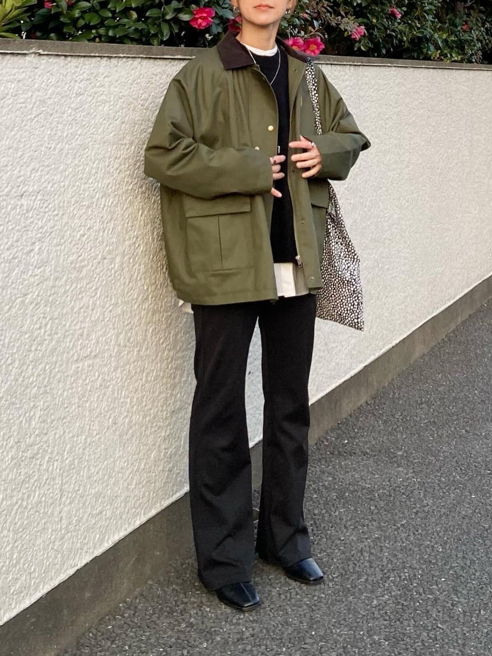 グリーン系のカバーオール、ブラック系のニット/セーター、ブラック系のその他パンツを着用したレディースの冬コーディネートの2枚目の写真