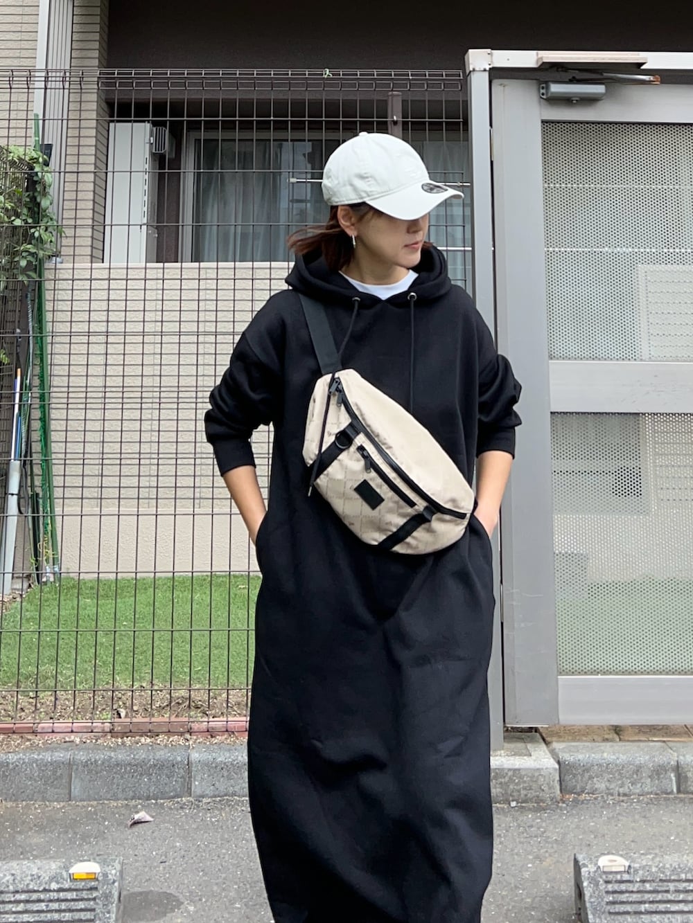 ブラック系のワンピース、その他のショルダーバッグ、ブラック系のスニーカーを着用したレディースの冬コーディネートの4枚目の写真