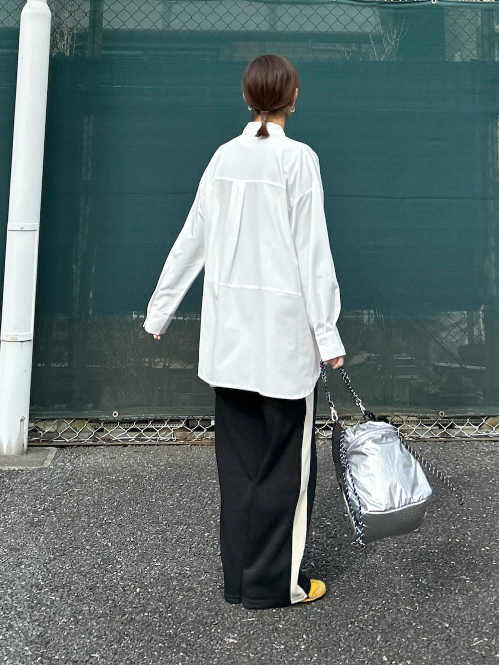 ホワイト系のシャツ/ブラウス、ブラック系のスラックス、シルバー系のショルダーバッグを着用したレディースの冬コーディネートの4枚目の写真