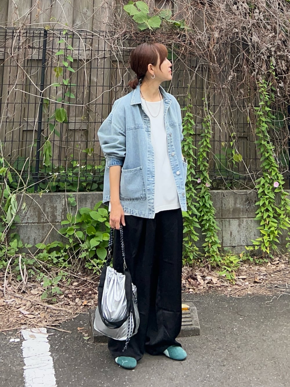 ブルー系のデニムジャケット、ホワイト系のTシャツ/カットソー、ブラック系のその他パンツを着用したレディースの春コーディネートの2枚目の写真