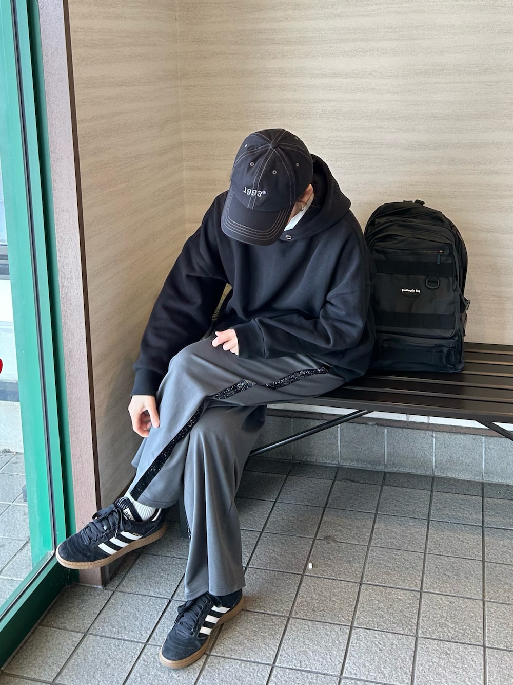 グリーン系のノーカラージャケット、ブラック系のパーカー、ブラック系のバックパック/リュックを着用したレディースの冬コーディネートの2枚目の写真