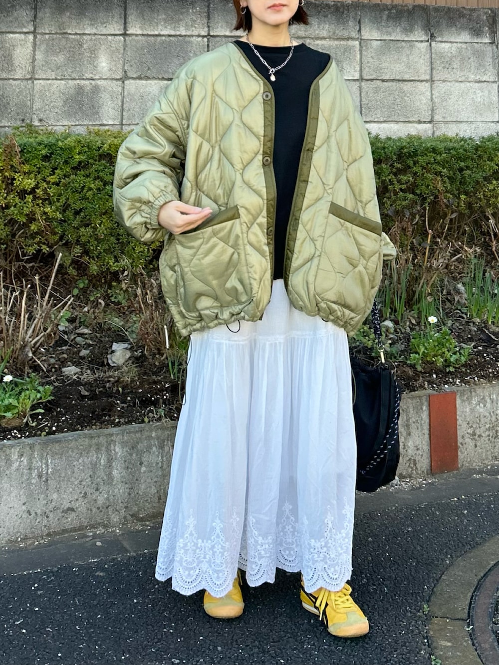 グリーン系のブルゾン、ブラック系のTシャツ/カットソー、ブラック系のトートバッグを着用したレディースの冬コーディネートの3枚目の写真