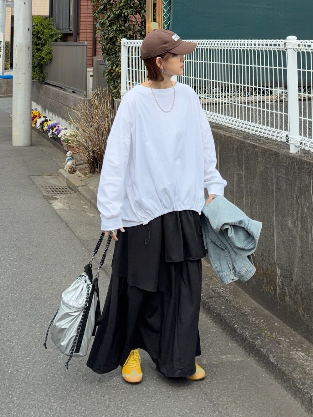 ホワイト系のTシャツ/カットソー、ブラック系のスカート、シルバー系のトートバッグを着用したレディースの春コーディネートの2枚目の写真