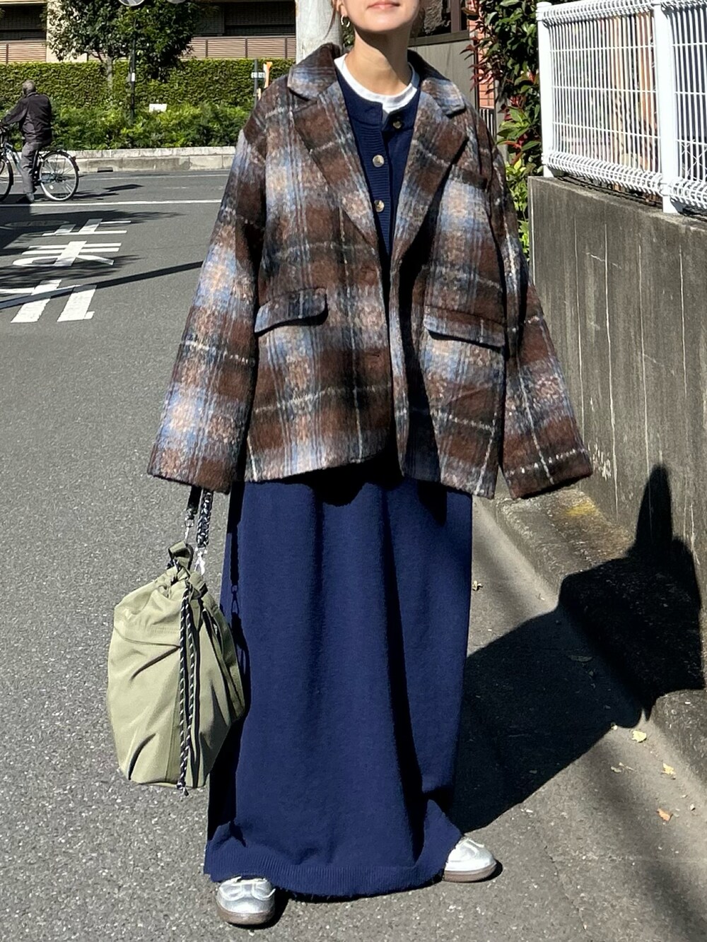 ブルー系のワンピース、ブラウン系のテーラードジャケット、グリーン系のトートバッグを着用したレディースの冬コーディネートの2枚目の写真