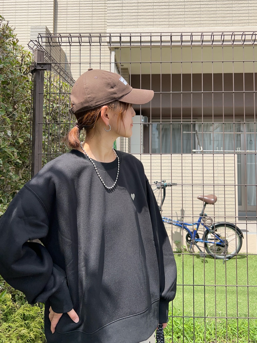 ブラック系のスウェット、ホワイト系のスラックス、ブラック系のトートバッグを着用したレディースの秋コーディネートの4枚目の写真