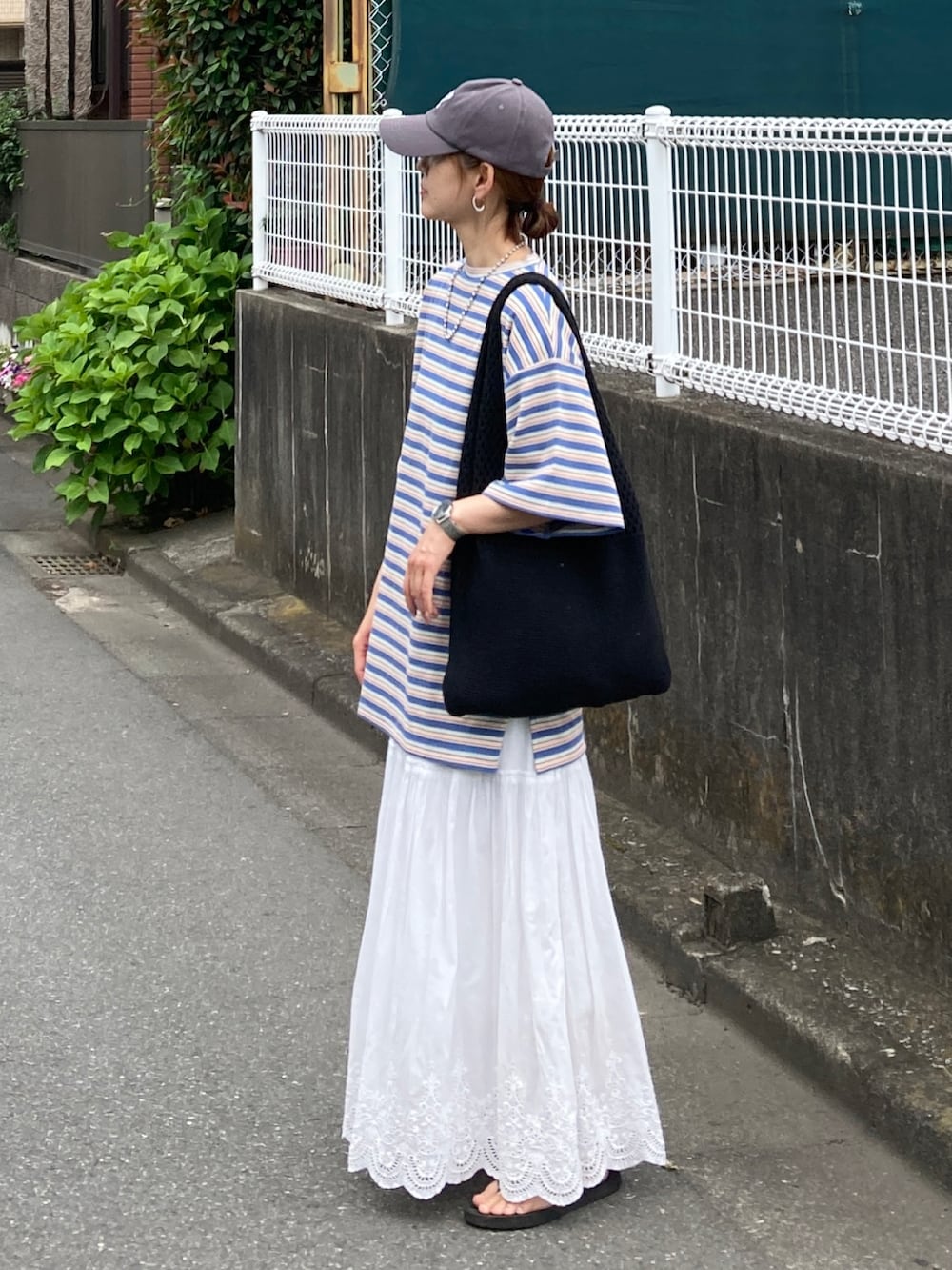 ブルー系のTシャツ/カットソー、ホワイト系のスカート、ブラック系のショルダーバッグを着用したレディースの夏コーディネートの2枚目の写真