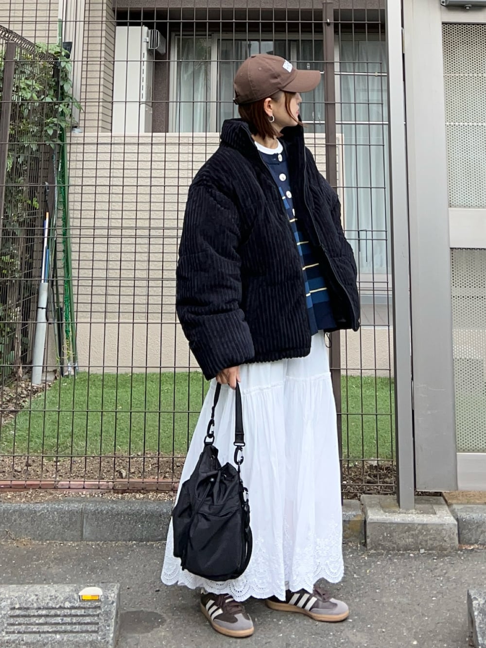 その他のニット/セーター、ブラック系のダウンジャケット/コート、ホワイト系のスカートを着用したレディースの冬コーディネートの2枚目の写真