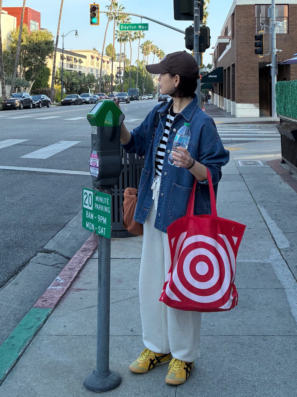ブラック系のTシャツ/カットソー、オレンジ系のショルダーバッグ、ブルー系のデニムジャケットを着用したレディースの春コーディネートの5枚目の写真